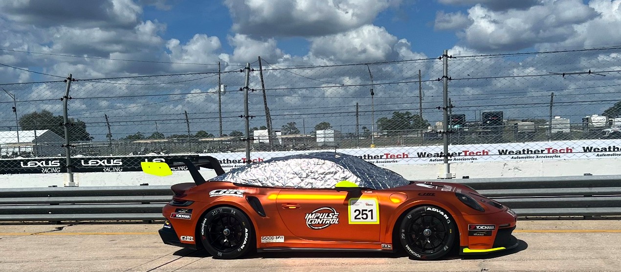 CHILLTOPS Thermal Reflective Cockpit Cover installed on an orange Porsche race car sitting in direct sunlight
